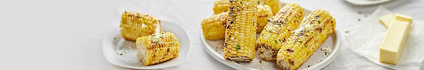 A plate of grilled corn on the cob.