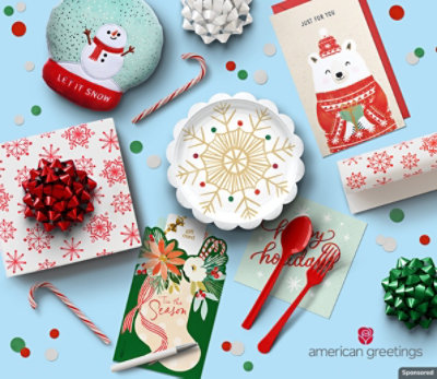 Christmas cards, gifts and party products sit on a blue background amid confetti and candy canes.