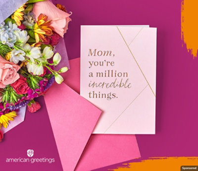 A bouquet of flowers laying next a Mother's Day card.