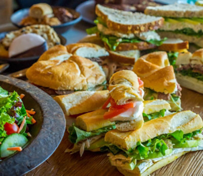 Various sandwiches and salads on a table top.