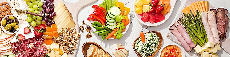 deli meats, cheeses and fruits on a board