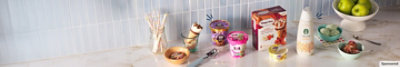 Assorted dairy products arranged on a counter with a bowl of ice cream and a cup of coffee.