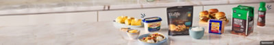 Assorted dairy products arranged on a counter with plated tacos, sweet corn and burgers.
