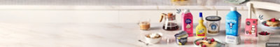 Assorted dairy products arranged on a counter for breakfast with a plate of pancakes. 