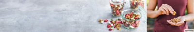 Woman snacking on walnuts. Walnut and dried strawberry trail mix.