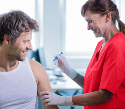 Doctor with patient and vaccine at clinic