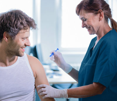Doctor with patient and vaccine at clinic