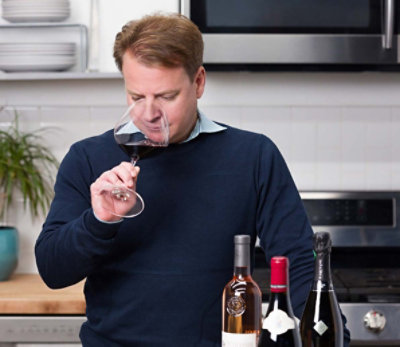 Curtis Mann, our in-house wine expert, smelling red wine from a wine glass in a kitchen