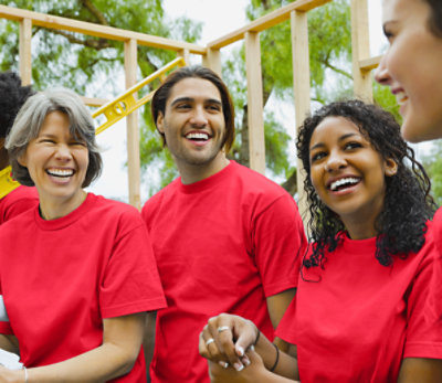 Four people in red shirts laughing outside