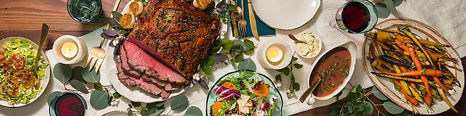 Holiday dinner with roast beef, roasted carrots, and salads 
