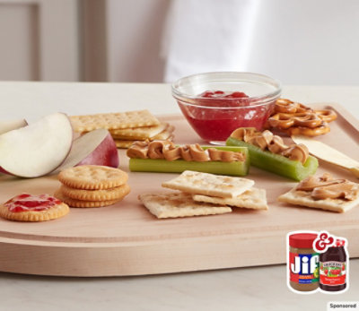 A bowl of yogurt topped with Jif peanut butter, Smucker’s fruit spread and granola.