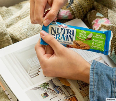 Person opening a Kellanova Nutri-Grain bar.