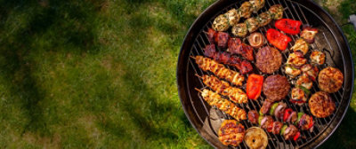  Variety of grilled food options spread out on a grill on top of grass