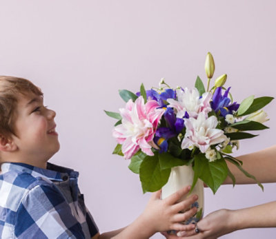 A child accepting flowers from mother