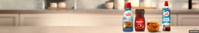 Packages of Necafe and Coffee mate lined up on a countertop.