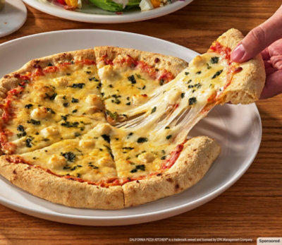 Slice of California Pizza Kitchen Neapolitan-Inspired Pizza getting picked up, showing cheese pull.