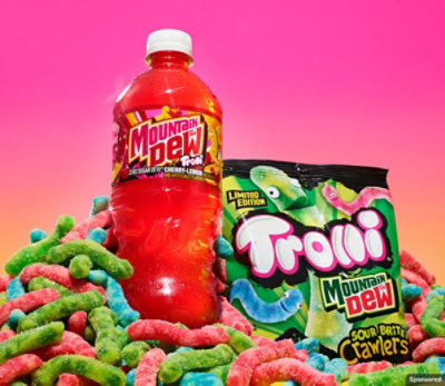 Mountain Dew Trolli bottle and Trolli Mountain Dew packet on a pile of Trolli gummy worms on a gradient background.