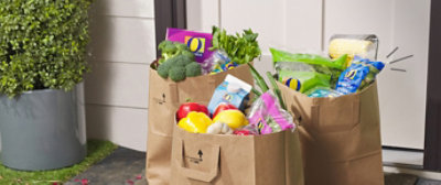  Three bags of various groceries at doorstep.