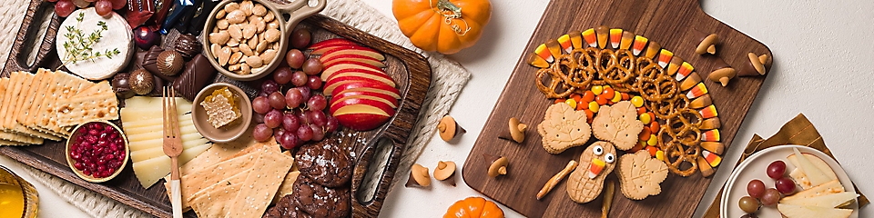 Two charcuterie boards placed next to some pumpkin decors.
