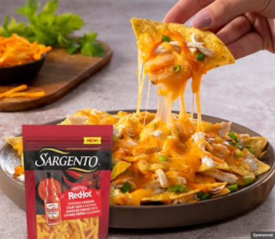 Spicy Buffalo Chicken Nachos made with Sargento® Frank's Red Hot® Seasoned Shredded Cheese.