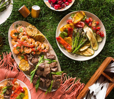 Seafood, vegetables and meat on plates for a grass picnic