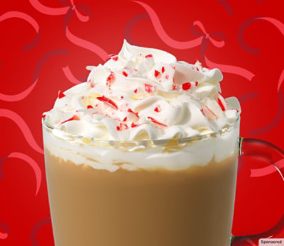 A mug of peppermint mocha coffee on a red background.