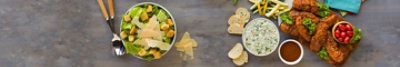 A tray of fried chicken, a bowl of dip with bread, and a bowl of salad