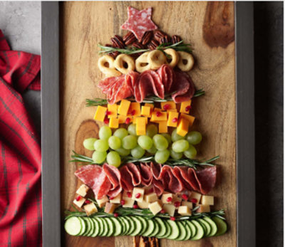 Charcuterie platter of cheese, meats, and fruits in the shape of a Christmas tree.