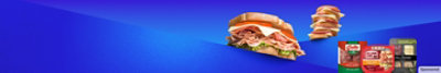 A sandwich piled high with delicious lunch meat and a stack of tasty meat, cheese and crackers.