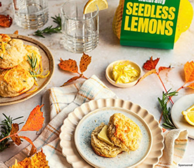 Plates of scones with butter on a festive, fall table by Wonderful Seedless Lemons.