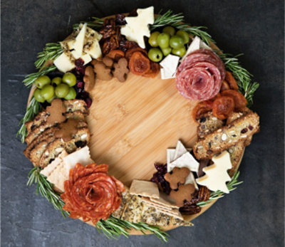 Charcuterie platter of cheese, meats, and fruits in the shape of a Christmas wreath.